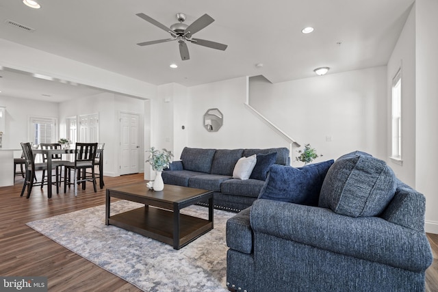 living room featuring a healthy amount of sunlight, dark hardwood / wood-style flooring, and ceiling fan