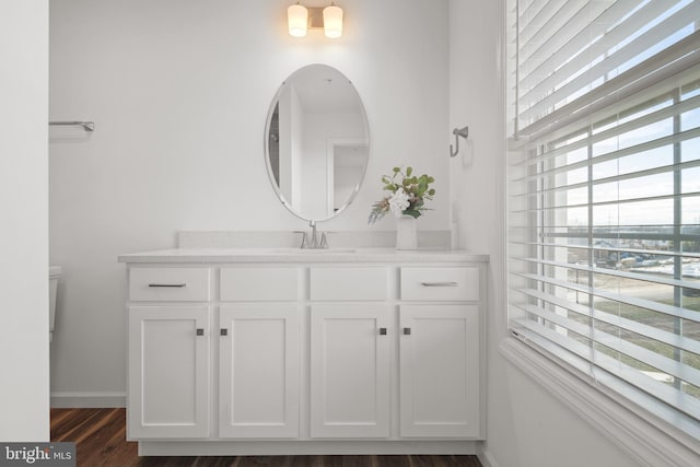 bathroom featuring toilet, hardwood / wood-style flooring, and vanity