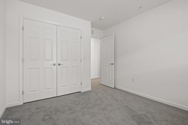 unfurnished bedroom with a closet and light colored carpet