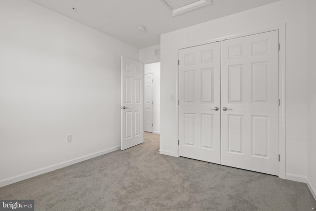 unfurnished bedroom with light carpet and a closet