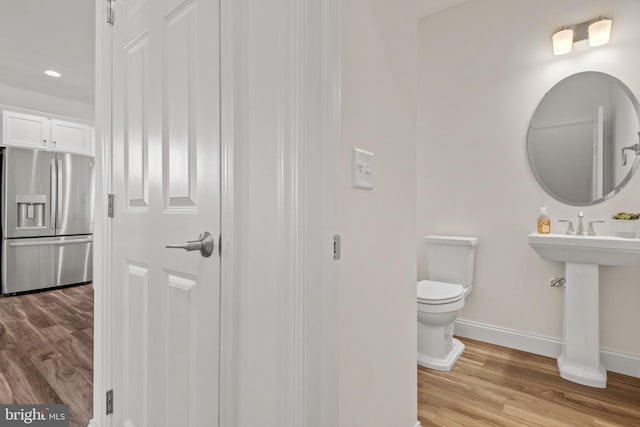 bathroom featuring hardwood / wood-style floors, sink, and toilet