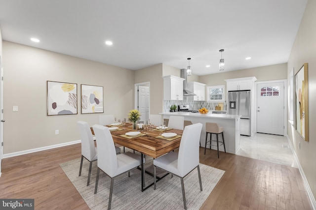 dining space with light wood finished floors, baseboards, and recessed lighting