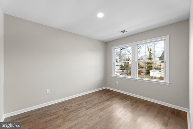 spare room featuring baseboards, visible vents, wood finished floors, and recessed lighting