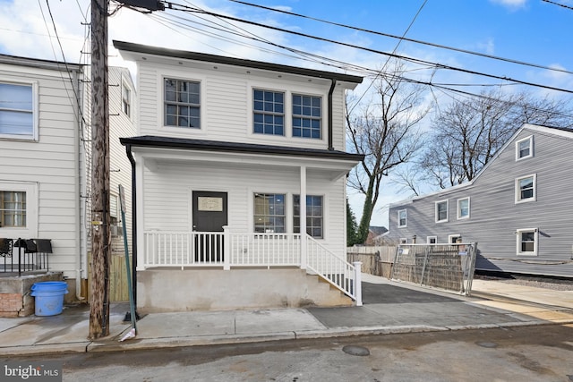 view of front of house with a porch and fence