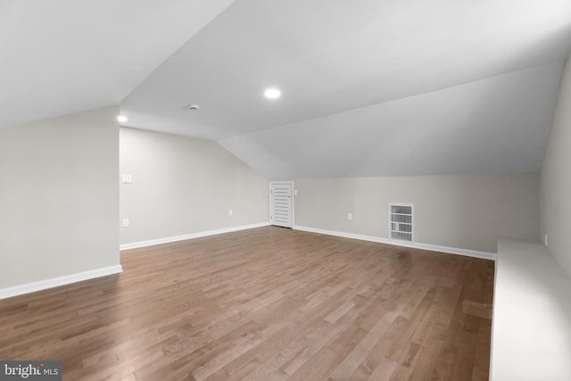 additional living space featuring lofted ceiling, recessed lighting, wood finished floors, and baseboards