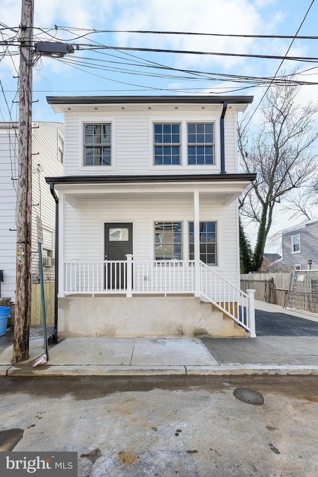 view of front of home with covered porch and fence