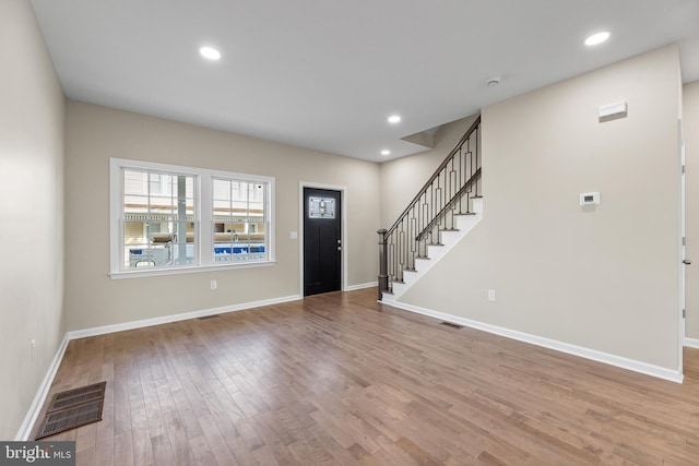 foyer with stairs, recessed lighting, visible vents, and wood finished floors