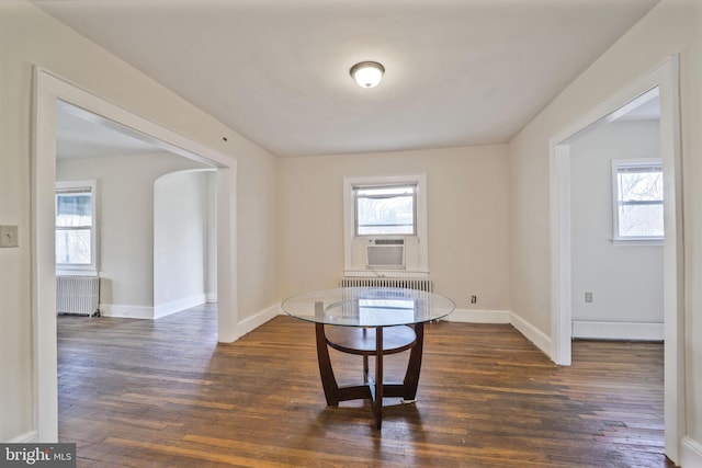 dining area featuring a wealth of natural light, baseboards, radiator heating unit, and wood finished floors