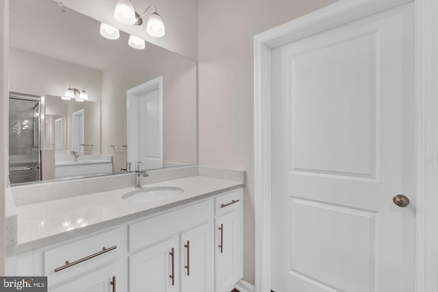 bathroom with a shower with shower door and vanity