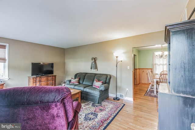 living room featuring a chandelier, a wealth of natural light, and light wood-style floors