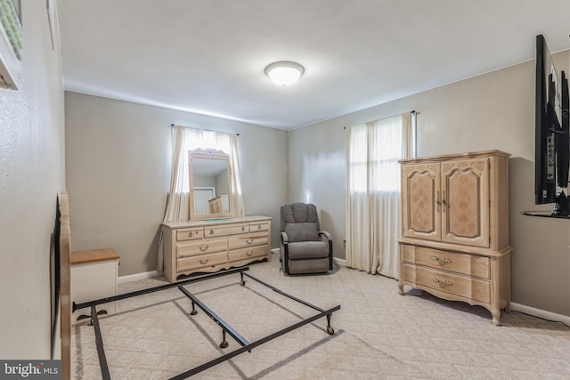 bedroom with light colored carpet and baseboards