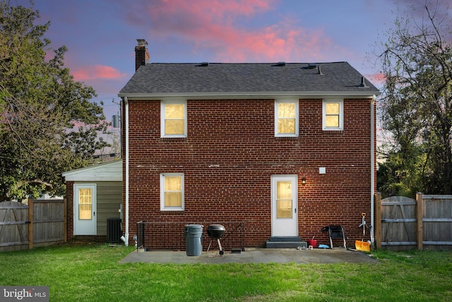 507 Janneys Ln, Alexandria, VA 22302 - back of house at dusk with a chimney, brick siding, a patio, roof with shingles, and cooling unit