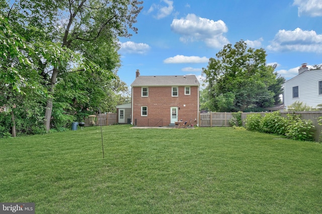 507 Janneys Ln, Alexandria, VA 22302 - rear view of house with brick siding, a chimney, and a patio area