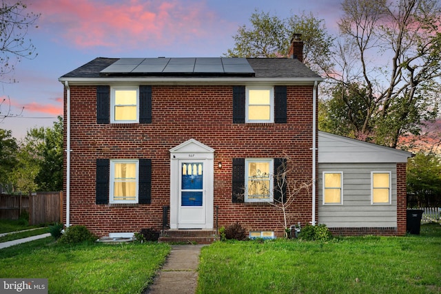 507 Janneys Ln, Alexandria, VA 22302 - view of front facade featuring a chimney, roof mounted solar panels, entry steps, and brick siding
