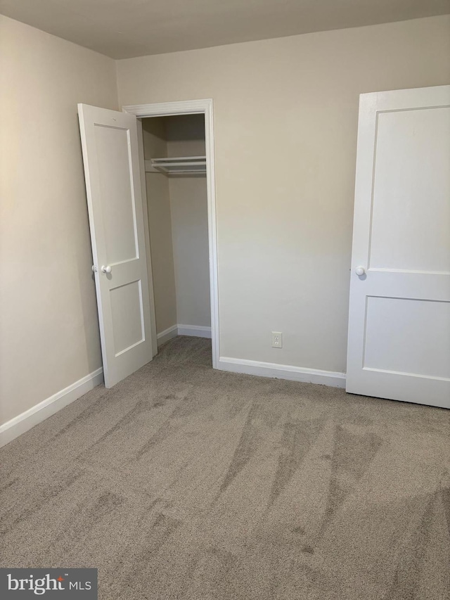 unfurnished bedroom with a closet and carpet