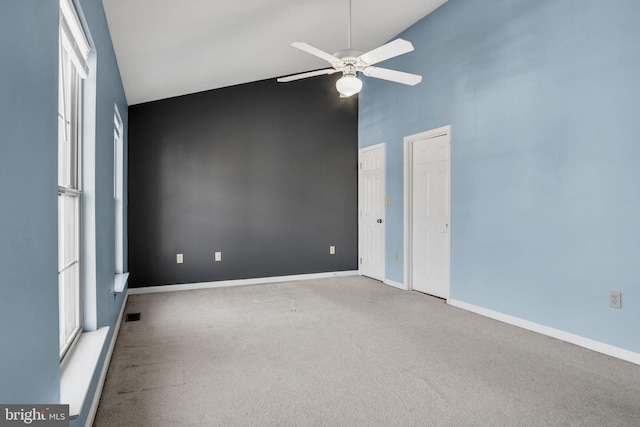 unfurnished bedroom with two closets, high vaulted ceiling, ceiling fan, and carpet