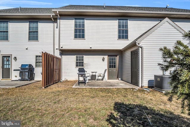 back of property with cooling unit, a yard, and a patio area