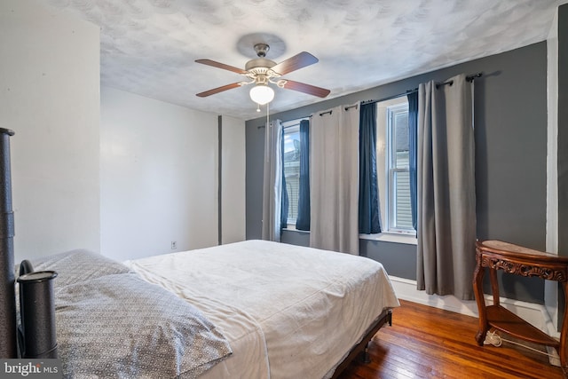 bedroom with ceiling fan and dark hardwood / wood-style flooring