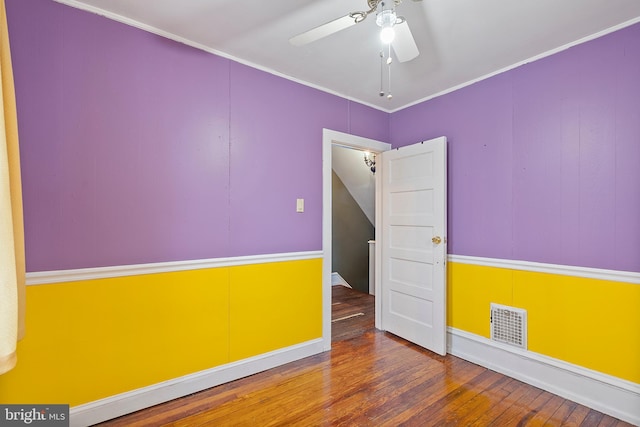 unfurnished room featuring wood-type flooring, ornamental molding, and ceiling fan