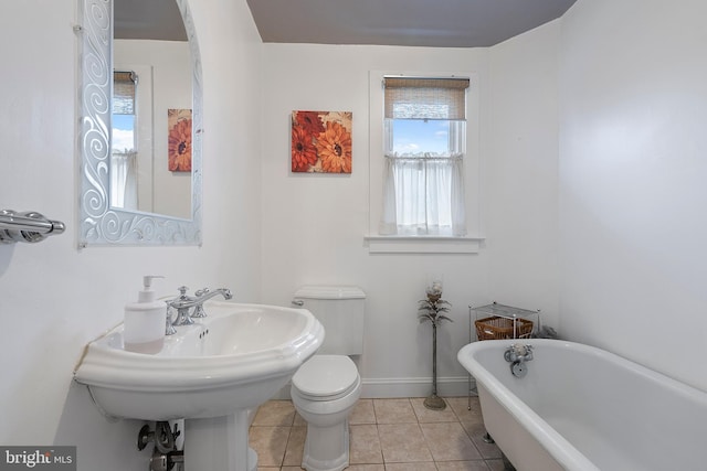 bathroom with sink, toilet, tile patterned flooring, and a tub