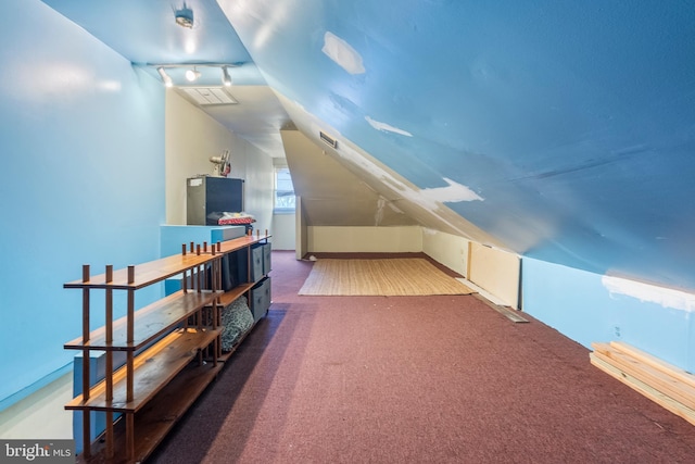 bonus room featuring vaulted ceiling and dark carpet