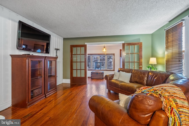 living room with dark hardwood / wood-style flooring and a textured ceiling