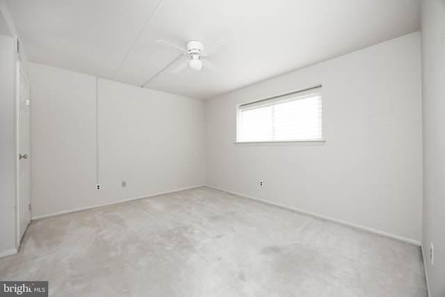 carpeted spare room featuring ceiling fan