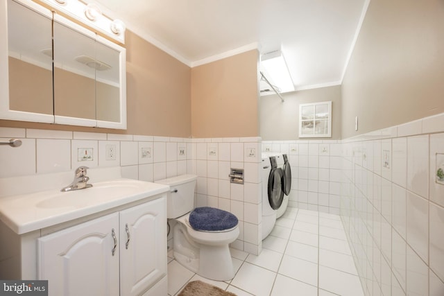 bathroom featuring washing machine and clothes dryer, vanity, toilet, and ornamental molding