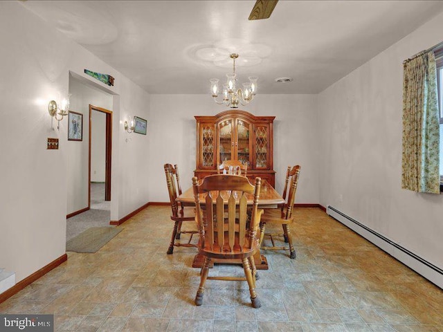 dining area featuring stone finish floor, baseboards, a chandelier, and baseboard heating