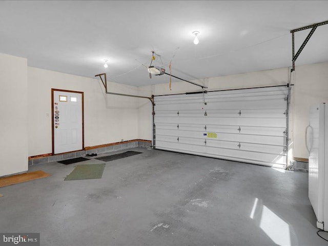 garage with freestanding refrigerator and a garage door opener