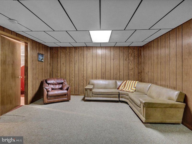 carpeted living room with wooden walls