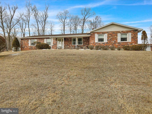 ranch-style home with a front yard and brick siding