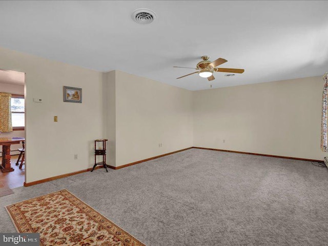 unfurnished living room with light carpet, a ceiling fan, visible vents, and baseboards