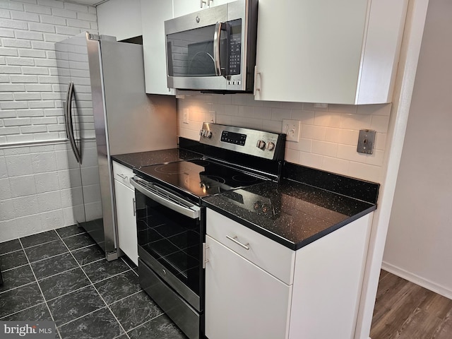 kitchen with white cabinetry, backsplash, and stainless steel appliances