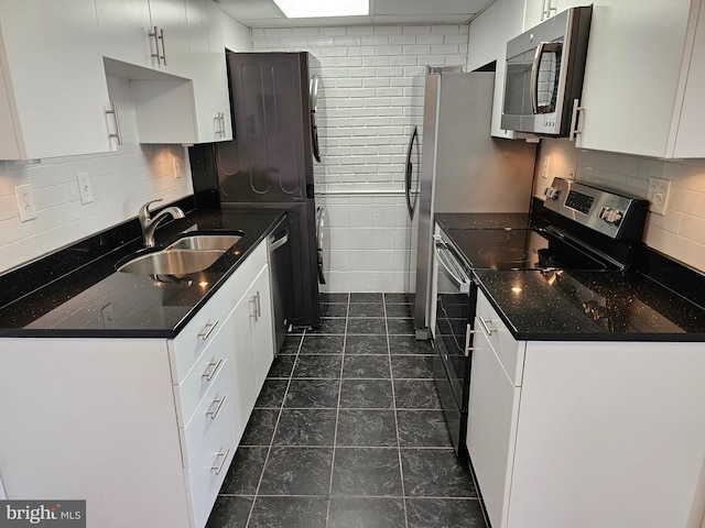 kitchen featuring white cabinetry, appliances with stainless steel finishes, sink, and backsplash