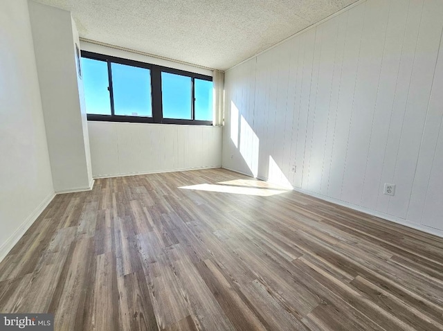 spare room featuring hardwood / wood-style flooring and a textured ceiling