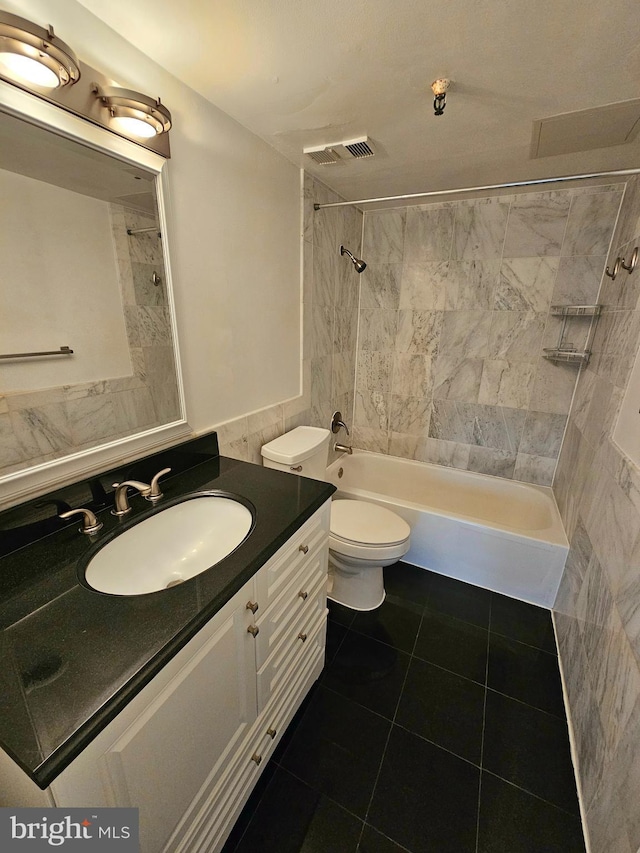 full bathroom featuring tiled shower / bath combo, tile patterned floors, toilet, and vanity