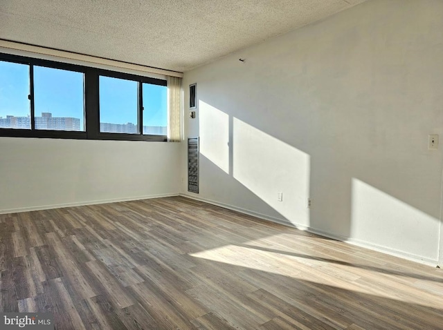 empty room featuring wood-type flooring and a textured ceiling