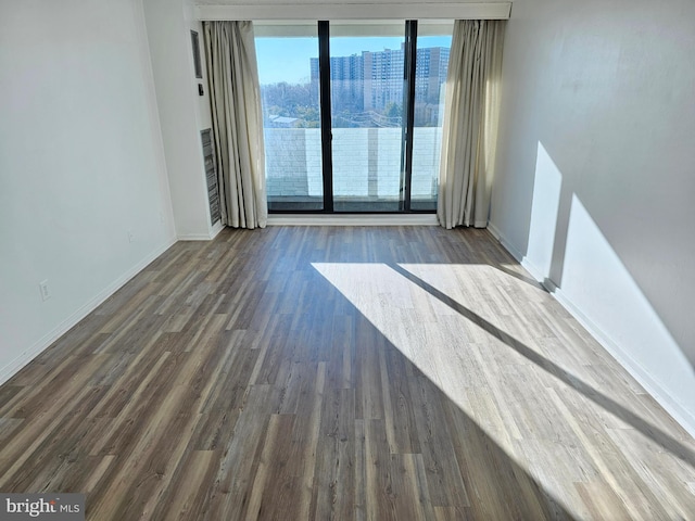 unfurnished room with dark hardwood / wood-style flooring