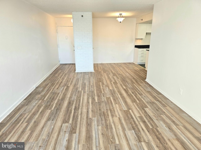 unfurnished room with light hardwood / wood-style floors and a textured ceiling