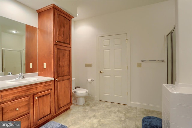 bathroom with vanity, toilet, and a shower with shower door