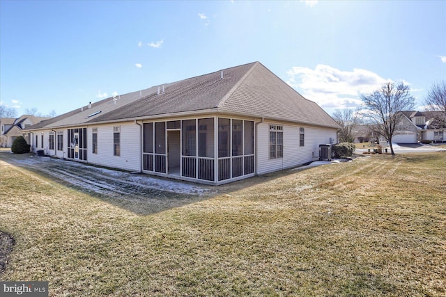 back of property featuring a lawn, a sunroom, and cooling unit