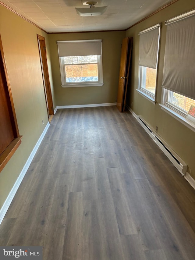 interior space featuring baseboards, a baseboard heating unit, and wood finished floors