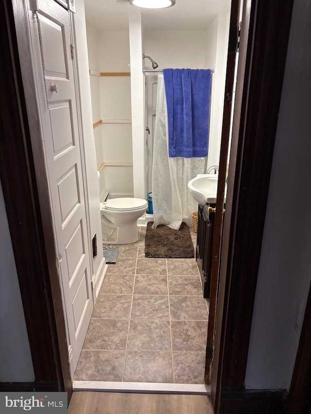 bathroom with curtained shower, a sink, and toilet