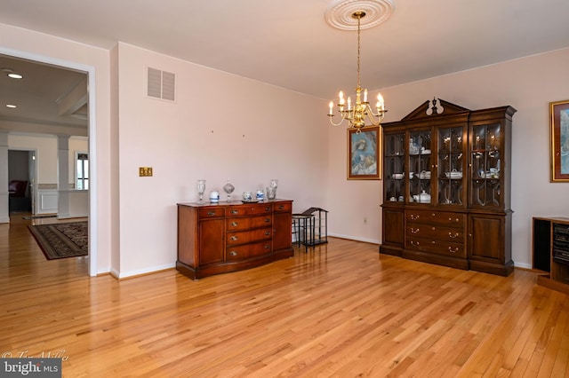 dining room with light wood-style floors, a chandelier, visible vents, and baseboards