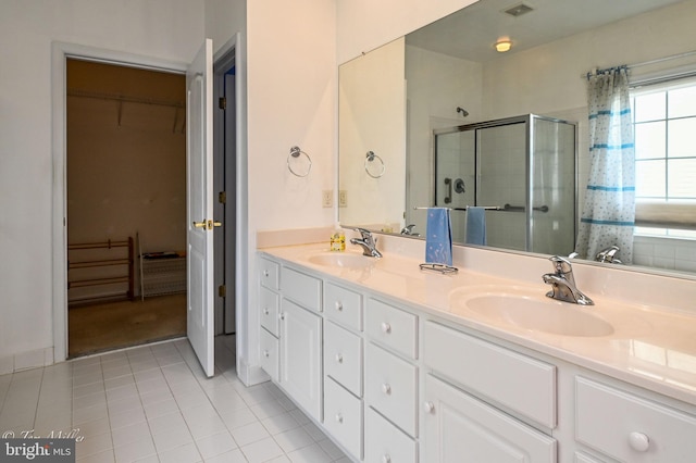 full bathroom featuring a spacious closet, tile patterned flooring, a sink, and visible vents