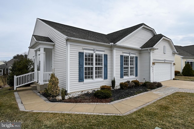 view of side of property with a garage, concrete driveway, roof with shingles, and a yard