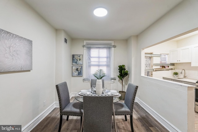 dining room with dark hardwood / wood-style flooring and sink