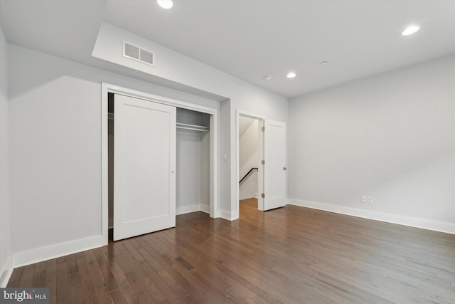 unfurnished bedroom featuring dark hardwood / wood-style floors and a closet