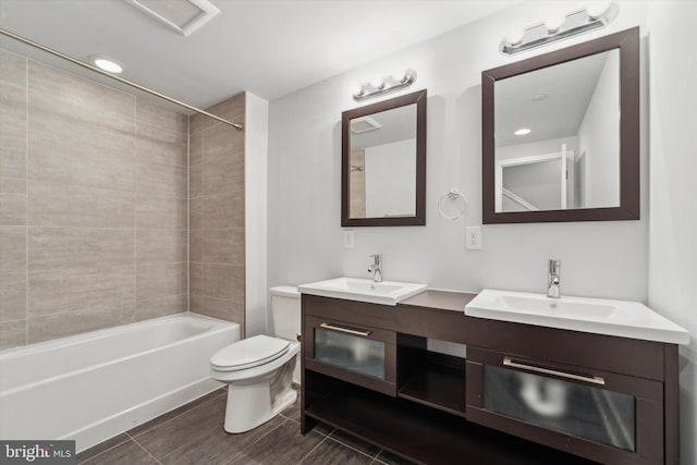 full bathroom with tiled shower / bath, vanity, and toilet